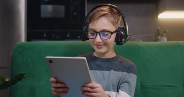 Zbliżenie Cute Uśmiechnięty Inteligentny Chłopiec Pomocą Tabletu Cyfrowego Przeglądania Strumieniowego — Wideo stockowe