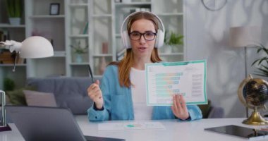 Blogger etkileyicisi. Memnuniyet verici bayan video blogu web kamerasından canlı yayında. Kadın vlogger, dokümanları gösteren heyecan verici ticari içerik değerlendirmesi çekiyor. Yavaş çekim.