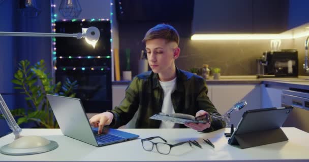 Подросток Использует Ноутбук Держит Руках Компьютерную Доску Читает Инструкции Структуре — стоковое видео