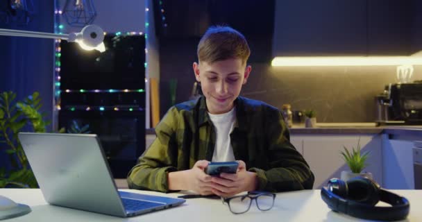 Succesvolle Tienerjongen Zittend Aan Tafel Met Smartphone Thuis Leersucces Mondiaal — Stockvideo