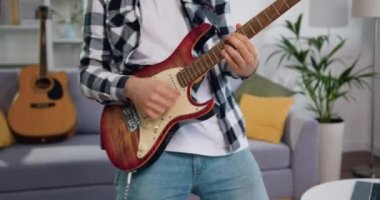 Genç müzisyen modern odada şarkı söylüyor ve elektro gitar çalıyor mutlu ve çılgın, eğleniyor, müzik dinliyor ve dans ediyor. Yavaş çekim.