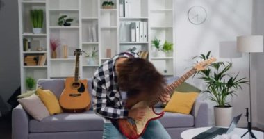 Neşeli rock 'çı adam elektro gitar çalıp saçlarını sallıyor. Sakallı adam dans ederek ve müzik dinleyerek iyi eğlenceler. İnsanlar hafta sonları boş zaman aktiviteleri yapar. Yavaş çekim.