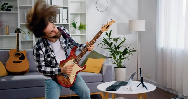 Neşeli rock 'çı adam elektro gitar çalıp saçlarını sallıyor. Sakallı adam dans ederek ve müzik dinleyerek iyi eğlenceler. İnsanlar hafta sonu boş zaman aktiviteleri.