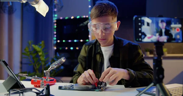 道具を持った眼鏡の白人の少年は 家庭用電子機器を修理する 男性プロの少年がコンピュータを修理する エンジニア マイクロソルダリング回路 — ストック写真