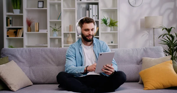 Junger Mann Mit Kopfhörern Sitzt Auf Dem Sofa Laptop Und — Stockfoto