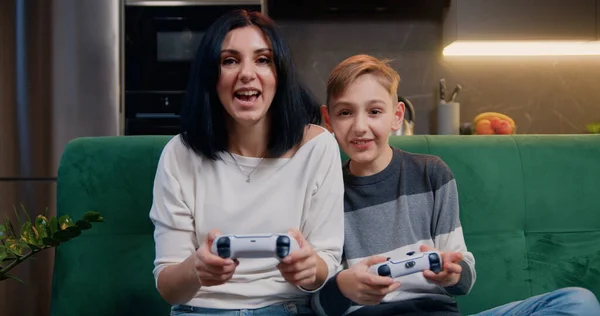 屋内アクティビティを楽しむモダンなキッチンアパートで一緒にビデオゲームをしている若い笑顔の女性と息子 オンラインエンターテイメントとレジャー活動のコンセプト — ストック写真