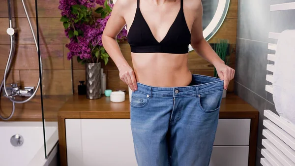Schudnąć Koncepcja Gdzie Szczupła Piękna Kobieta Dużych Dżinsach Pokazując Swoją — Zdjęcie stockowe
