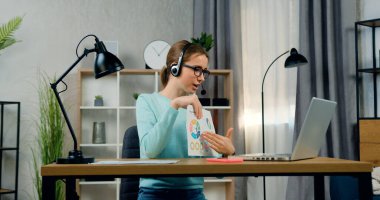 Çevrimiçi seminer, uzaktan eğitim konsepti sırasında raporunu üniversite öğretmenine sunan kulaklıklı 20 yaşında kendinden emin bir bayan öğrenci.