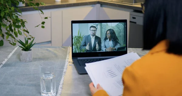Beautiful confident experienced adult modern businesswoman sitting at home in front of laptop during video meeting with african american female partner within joint business project,distantly business