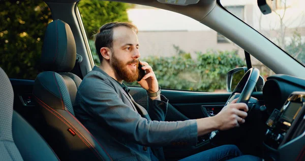 Genç şoför arıyor, telefon kullanıyor. konsept, araç ve ulaşım. Kendine güveni tam bir iş adamı modern bir arabada oturan akıllı bir adamdan bahsediyor..
