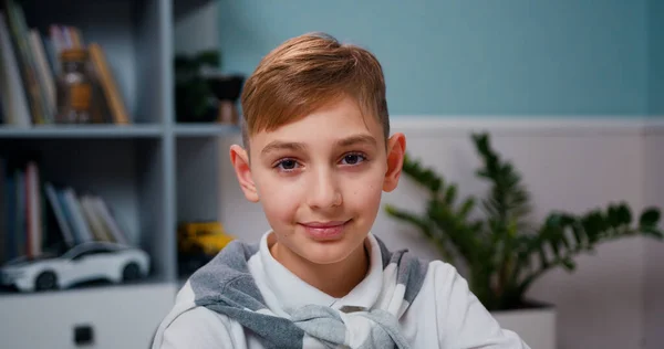 Portrait of young cheerful happy smiling asian chinese high schoolboy looking at camera and smiling kindly. Thoughtful kid boy eyes thinking.