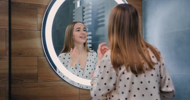 漂亮的年轻女士在家里浴室的镜子里 女性日常事务 身体护理 生活方式 慢动作 — 图库视频影像