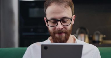 Gözlüklü, dijital tablet ekranlı bir iş adamı sosyal medyada sohbet ediyor, internetten mal seçiyor. Kapat. Teknoloji konsepti olan internet. Yavaş çekim.