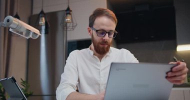 İşadamı odaklı girişimci bilgisayarında daktilo yazarak ofis masasında oturuyor uzaktan çalışan notlar alıyor. Freelancer ev hazırlama raporundan laptopunu iş için kullanıyor. Yavaş çekim.