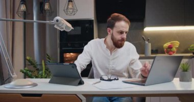 Mutlu adamın portresi dizüstü bilgisayar ve tablet daktilo kullanarak büyük kazanç elde etti. İyi haber, zaferi sınıf dairesinde kutlayın. Neşeli çocuk bilgisayardan iyi haberler okuyor. Yavaş çekim.
