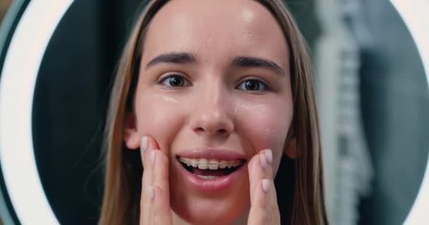Stäng Skrattande Flicka Tillämpa Återfuktande Kräm Ansiktet Porträtt Ansikte Ung — Stockvideo