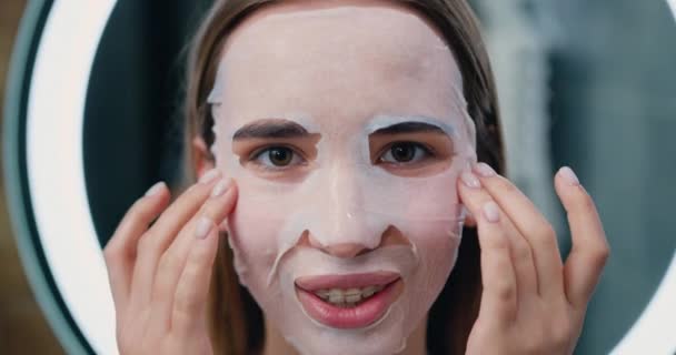 Närbild Ung Flicka Med Ansiktsmask Tittar Kameran Bakgrunden Spegeln Badrummet — Stockvideo