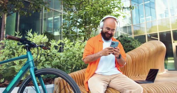 Joyeux Hipster Homme Lunettes Écouteurs Utilisant Smartphone Écrit Sur Les — Video