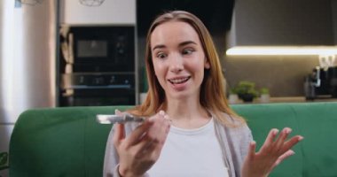 Neşeli güzel kız evdeki rahat koltukta otururken sesli mesajları kaydetmek için akıllı telefon kullanıyor. Evden uzakta çalışan bir kadın, telefonla konuşan serbest çalışan bir işçi. Yavaş çekim