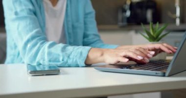 Bilgisayar klavyesinde ve akıllı telefonda tanınmayan bir kadının ünlü ellerini kapat. Mutfakta oturan bir kadın dizüstü bilgisayar ve cep telefonuyla yazı yazıyor. İnternet teknolojileri kavramı