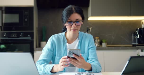 Женщина Очках Работающая Телефону Обменивается Сообщениями Смартфоном Современном Домашнем Офисе — стоковое видео