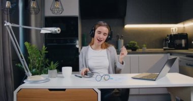 Güzel, 20 'li yaşlarda, kulaklıklı, müzik dinleyen, telefon kullanan modern oturma odasında masa başında dans eden bir kız. Güzel kız içeride sıkı çalıştıktan sonra müzik dinler. Yavaş çekim