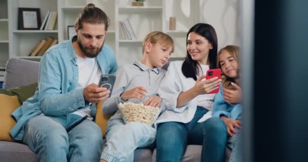 Familia Feliz Cuatro Disfrutar Usar Tecnología Teléfonos Inteligentes Relajarse Sentarse — Vídeos de Stock