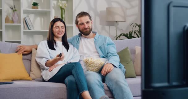 Piękna Kaukaska Para Młodych Ludzi Siedzących Kanapie Oglądających Telewizję Przystojna — Wideo stockowe