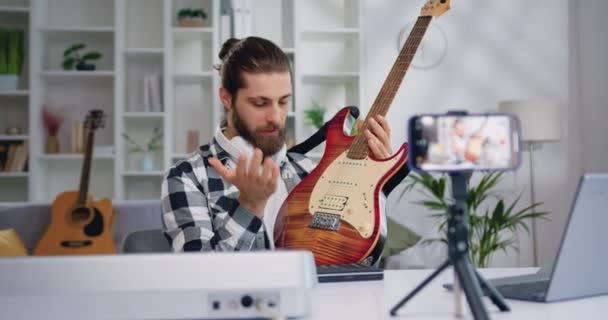 Junger Mann Gitarrenlehrer Spricht Die Kamera Und Zeigt Wie Spielen — Stockvideo