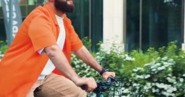 Güneşli bir günde sabit vites bisikleti süren bisikletçi. Şehir gezgini konsepti. Çekici yönetici kişisel asistanı işe giderken çevre dostu bir araçla gidiyor. Modern sağlıklı