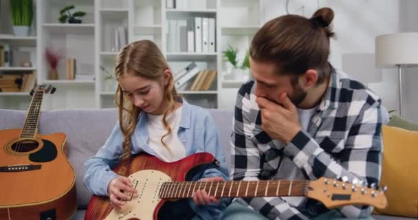 Beau Homme Assis Sur Canapé Enseignant Petite Fille Jouer Guitare — Video