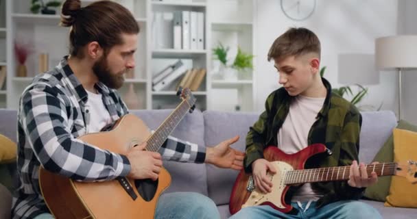 Talentoso Profesor Música Adolescente Estudiante Sentado Sofá Aprendiendo Tocar Guitarra — Vídeo de stock