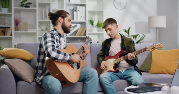 Professor Música Talentoso Estudante Adolescente Sentado Sofá Tocando Guitarra Juntos — Vídeo de Stock