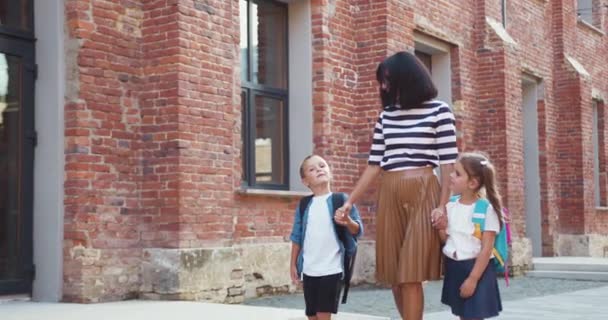 背着背包的孩子们奔向学校 小孩牵着妈妈的手母亲带着孩子的儿子去上课 到外面的城市散步 慢动作 — 图库视频影像