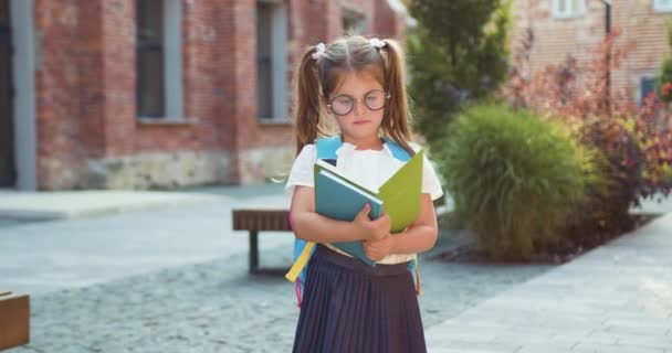 Beautiful Smiling Little Girl Glasses Backpack Reading Book While Standing — Stock Video