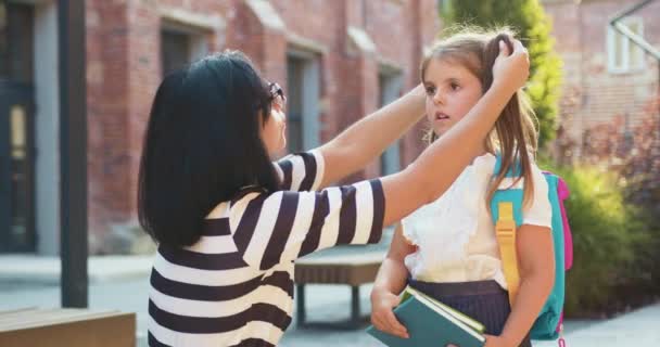 Mãe Ajudando Cuidar Menina Com Saco Livre Perto Edifício Escola — Vídeo de Stock