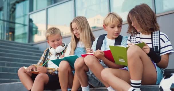 快乐的高加索同学在学校里聊天和做作业 在课间休息的时候坐在学校的楼梯上 在户外玩耍 回到学校的概念 慢动作 — 图库视频影像