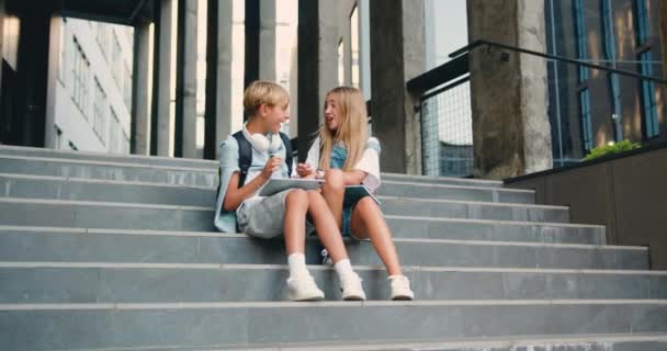 Crianças Escola Felizes Sentadas Perto Prédio Escola Nas Escadas Divertindo — Vídeo de Stock