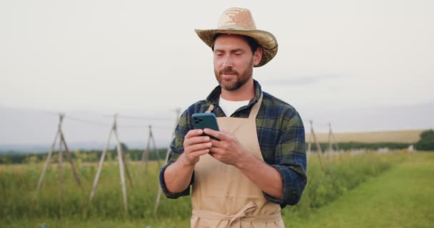 Hombre Agricultor Agrónomo Caminando Sosteniendo Teléfono Inteligente Sus Manos Comprobando — Vídeos de Stock