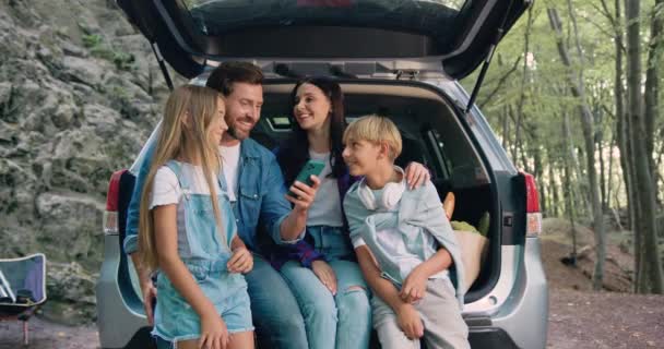 Fröhlich Schöne Eltern Mit Niedlichen Teenagerkindern Die Mit Dem Handy — Stockvideo