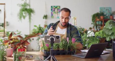 Küçük işletme girişimcisi bir fabrika sahibi akıllı telefon kullanarak sosyal ağlar için online çekim videosu çekiyor. Çiçekçilik, küçük işletmeler ve girişimcilik kavramı. Yavaş çekim.