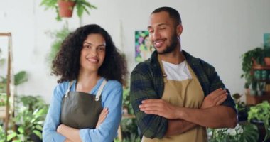 Afrikalı Amerikalı neşeli çiftin portresi önlüklü mutlu adam ve kadın kendi küçük çiçekçi dükkanında duruyor ve kameraya gülümsüyor. Aile işi konsepti. Yavaş çekim.