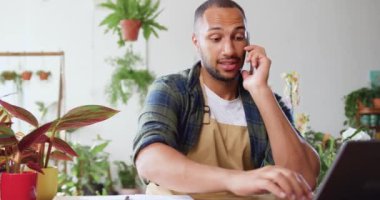 Fabrikada bir sürü yeşil fabrikanın arasında oturan bir iş adamı cep telefonuyla konuşuyor ve müşteriden sipariş alırken dizüstü bilgisayar kullanıyor. Dükkan sahibi online siparişleri, e-postaları ve daktiloyu kontrol ediyor.