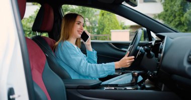 Çekici kızıl kadın arabada otururken akıllı telefondan konuşuyor. Günümüz otomobilinde Sunny Shore 'da duran kız sürücü akıllı telefonu arıyor. Çekici sarışın içeride telefonla konuşuyor..