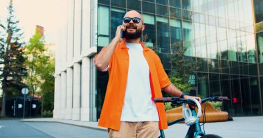 Turuncu tişörtlü ve güneş gözlüklü bir hippi dışarıda bisikletle yürürken akıllı telefondan yazı yazıyor. Kafkasyalı adam halka açık çevre taşımacılığını işe alıyor. İş, yaşam tarzı insan kavramı.