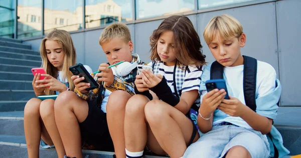 Tenager Uczniów Dwóch Białych Dziewcząt Chłopców Trzymających Telefon Komórkowy Przeglądania Obrazy Stockowe bez tantiem