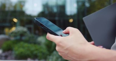 Kadın elinin kullandığı telefonu kapat. Cep telefonu kullanan ya da sohbet eden bir kadın eli. Açık havada. Yavaş çekim