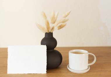 Boş kağıt tabaka. Kuru Lagurus ovatus otlu modern kırmızı seramik vazo ve bir fincan kahve. İskandinav iç tasarım seçici odak.