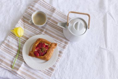 Kek, kahve ve sarı laleler. Nötr öğleden sonra yaşam tarzı kompozisyonu bej keten masa örtüsü.