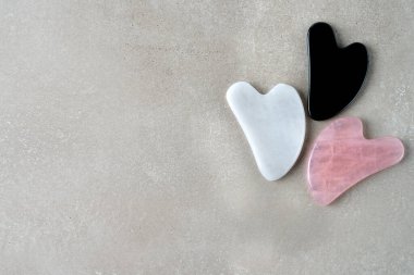 Gri arkaplanda Gua sha masaj taşı